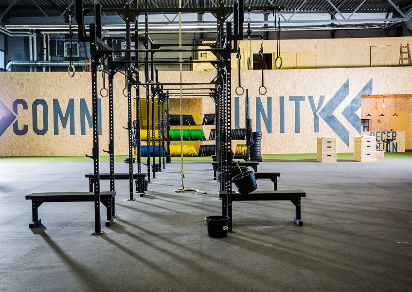 Latzuggerät mit Kabelzug und gepolsterter Sitzfläche im Trainingsbereich