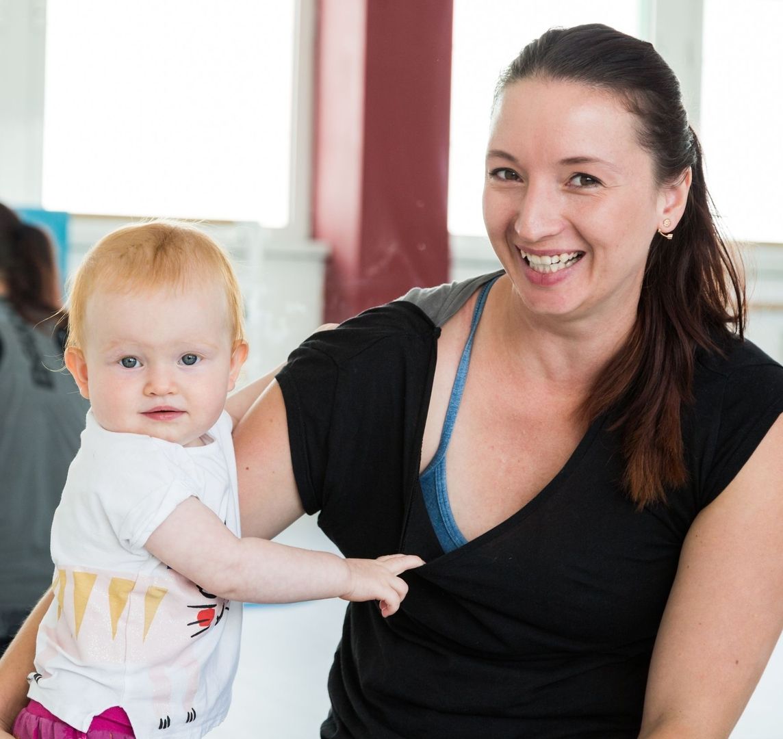Trainerin Andrea Hrdlicka mit einem Baby im Arm